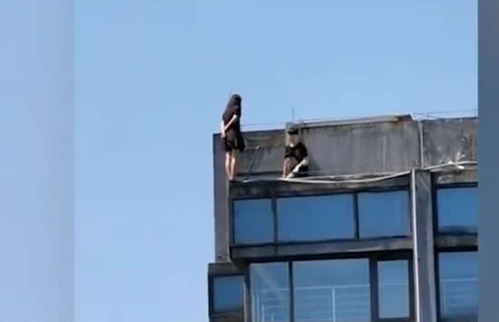 女子站30层楼顶边缘被一把拉回 救人男子身份疑似曝光