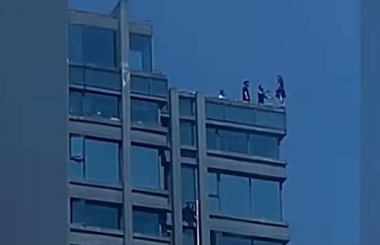 女子站30层楼顶边缘被一把拉回 救人男子身份疑似曝光