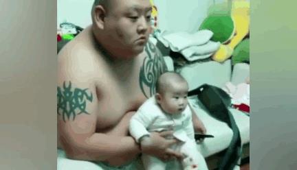 一对温馨的父子看电视表情神同步（图）