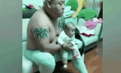 一对温馨的父子看电视表情神同步（图）